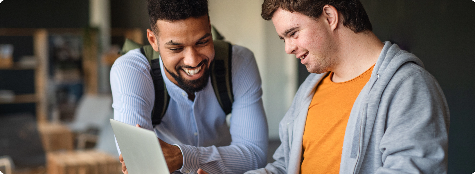 Man helping boy on laptop